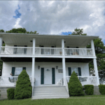 Greenhaven two-story farmhouse-style lodging in West Virginia with wraparound porches and countryside views