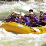 Group of rafters navigating whitewater rapids in West Virginia on a guided adventure in a yellow raft