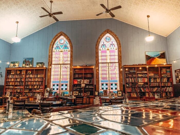Inside of Cathedral Cafe showing cozy bookshelves and beautiful stained glass windows