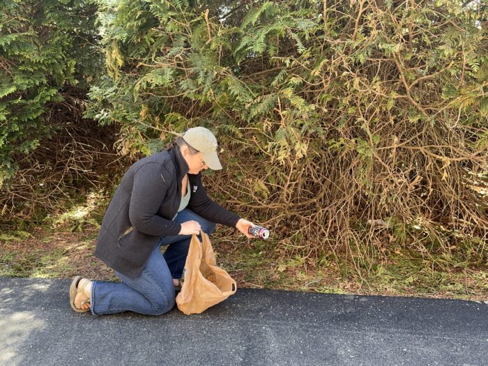 a woman picking up trash 