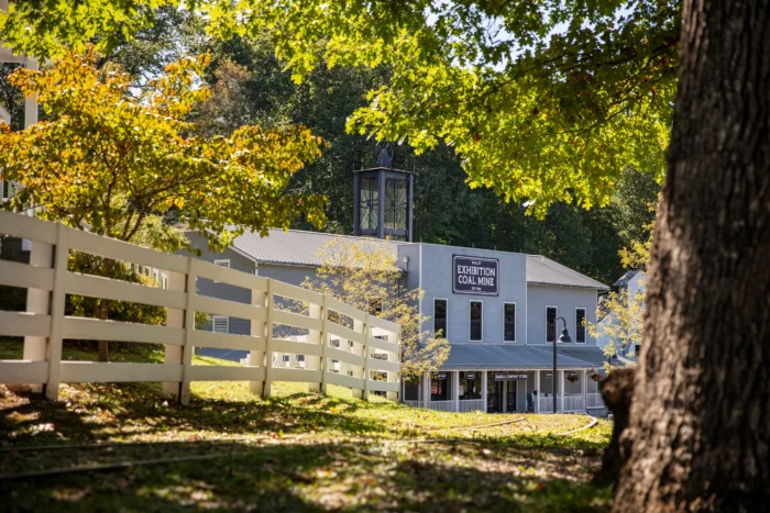 A historic **Exhibition Coal Mine** building with a white fence, surrounded by autumn trees with golden foliage.