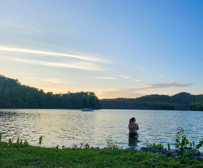 Swimmer entering lake at sunset